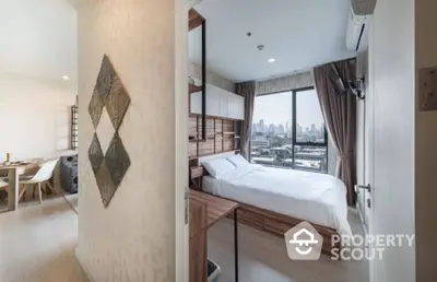 Modern bedroom with large windows offering a panoramic city view, complemented by a cozy bed and stylish wooden accents.