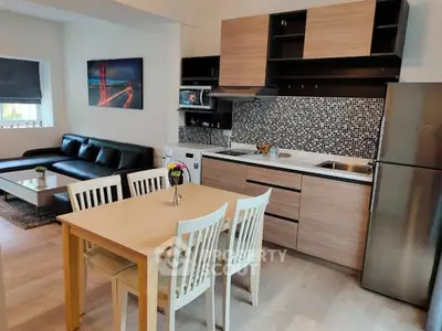 Modern open-layout kitchen and living room with stylish decor and sleek appliances.