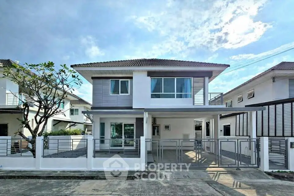 Modern two-story house with sleek design and spacious driveway in a serene neighborhood.