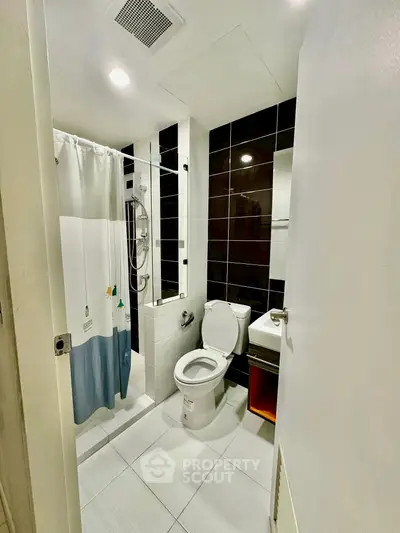 Modern bathroom with shower and sleek black tiles