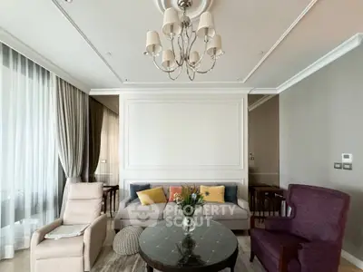 Elegant living room with plush seating and chandelier, perfect for relaxation and entertaining.