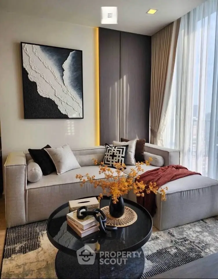 Modern living room with stylish decor, large window, and cozy seating area.