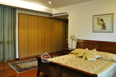 Elegant bedroom with wooden furniture and large wardrobe