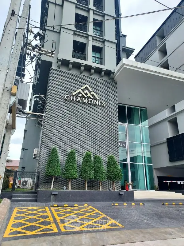 Modern building entrance with unique facade and well-maintained landscaping