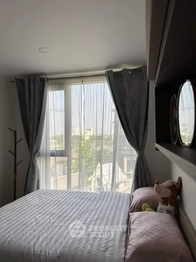 Sunlit bedroom with a large window offering a serene view, adorned with elegant curtains and a cozy bed, perfect for restful retreats in a modern home.