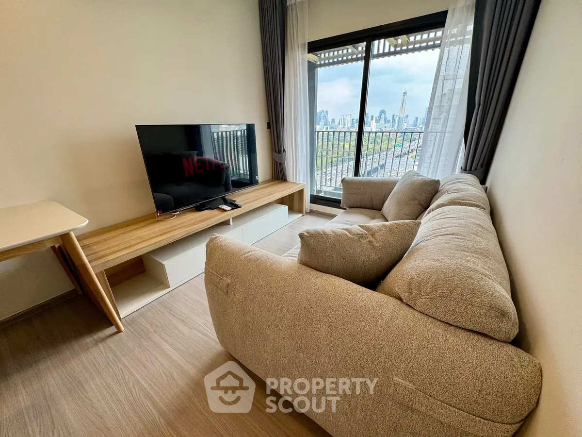 Modern living room with cozy sofa and city view balcony, perfect for relaxation and entertainment.