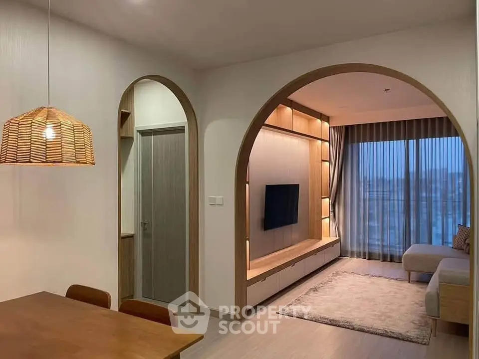 Modern living room with elegant archway, cozy seating, and ambient lighting for a stylish home atmosphere.