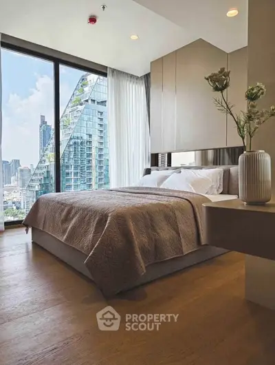 Luxurious bedroom with stunning city view and modern decor in high-rise apartment.