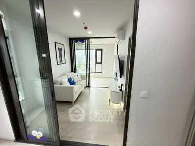 Modern living room with stylish decor and large windows offering city views.