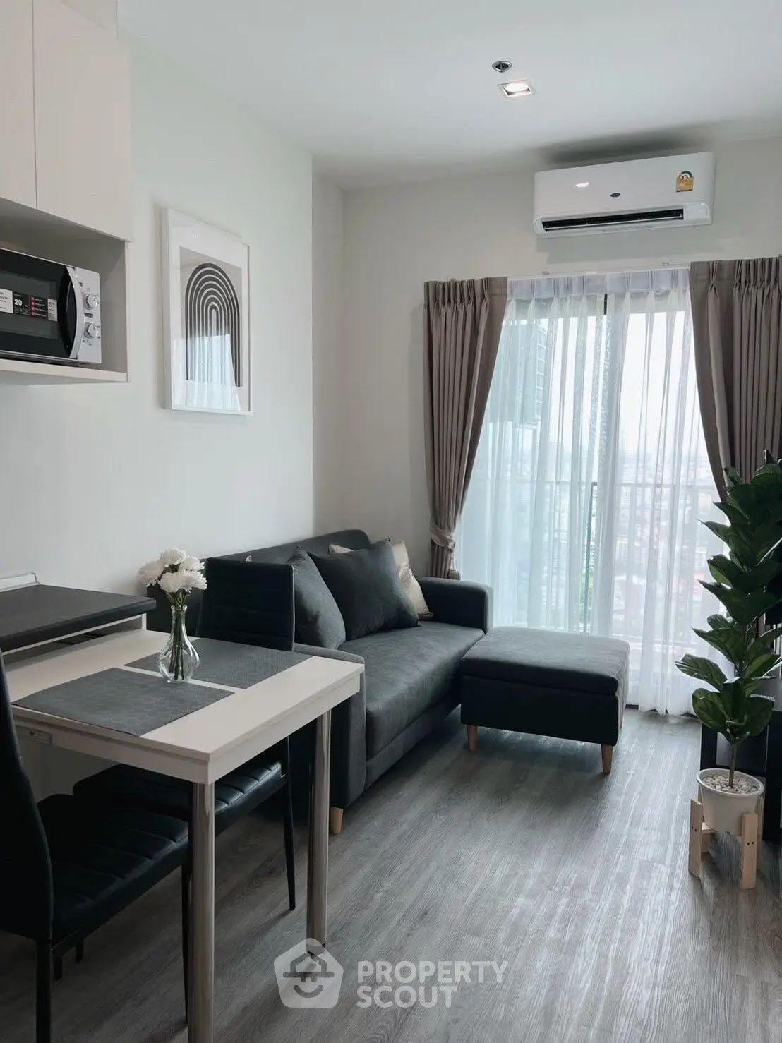 Modern living room with sleek furniture and large window offering natural light.