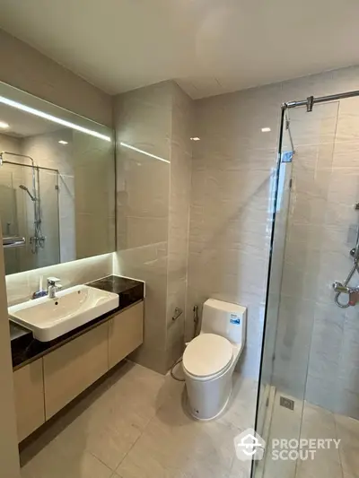 Modern bathroom with glass shower and sleek fixtures in luxury apartment