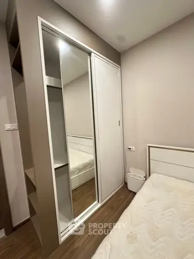 Modern bedroom with sleek mirrored wardrobe and minimalist design