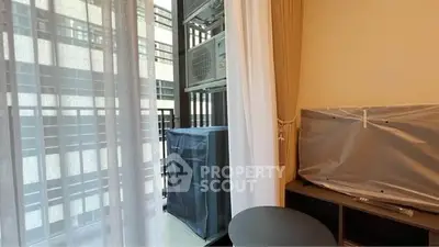 Modern apartment balcony with air conditioning unit and covered furniture.