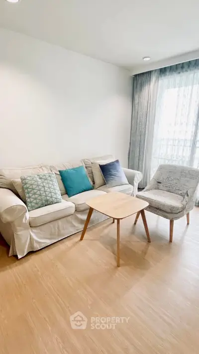 Modern living room with cozy sofa and stylish armchair, featuring elegant decor and natural light.