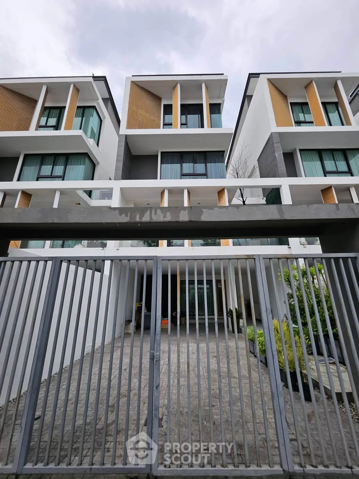 Modern multi-story residential building with sleek design and gated entrance