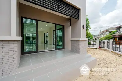 Modern house entrance with spacious patio and large glass doors