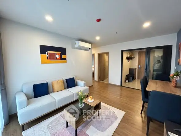 Modern living room with stylish decor and open layout, featuring a cozy sofa and elegant dining area.