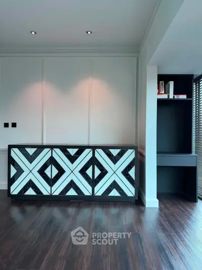 Stylish modern interior with geometric cabinet and sleek dark wood flooring, perfect for contemporary living.