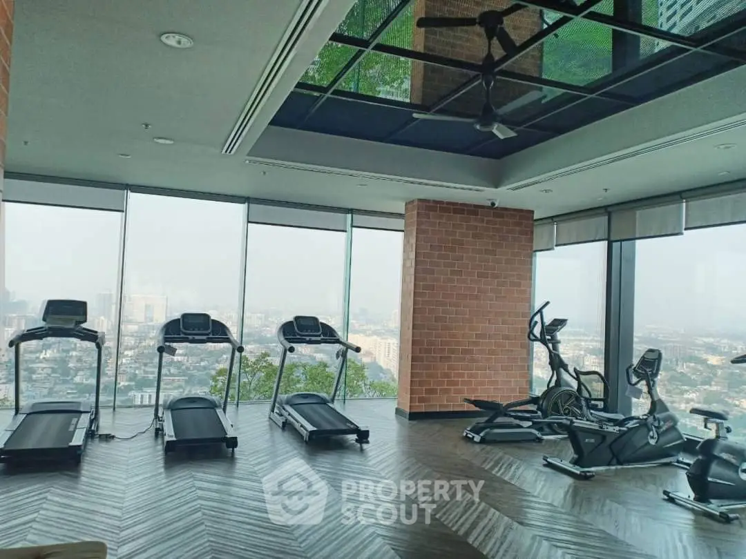 Luxurious high-rise gym with panoramic city views and modern equipment.