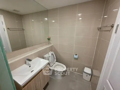Modern bathroom with sleek fixtures and large mirror in a contemporary home.