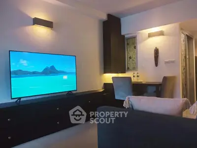 Modern living room with sleek furniture and large TV, perfect for relaxation and entertainment.