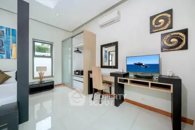 Modern bedroom with sleek furniture and stylish decor, featuring a built-in wardrobe and a desk with a computer.