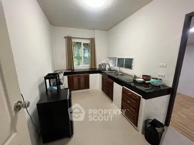 Modern kitchen with sleek countertops and ample storage in a cozy apartment.