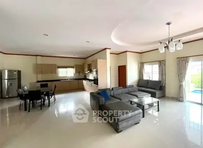 Spacious open-plan living room with modern kitchen and elegant furnishings