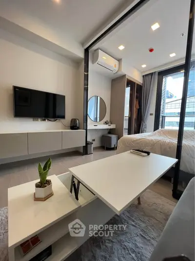 Modern studio apartment with sleek design, featuring a cozy living area and stylish bedroom with city views.