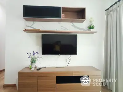 Modern living room with wall-mounted TV and stylish wooden shelves.