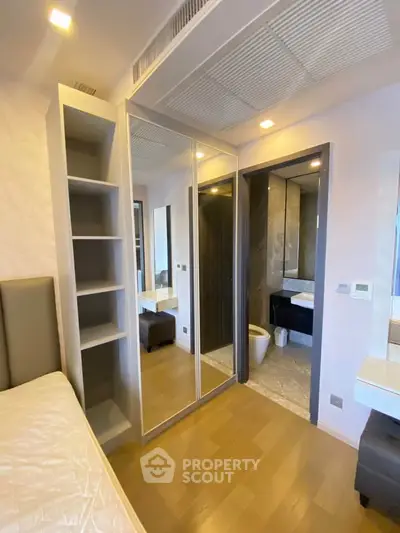 Modern bedroom with mirrored closet and ensuite bathroom in luxury apartment