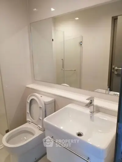 Modern bathroom with sleek fixtures and large mirror