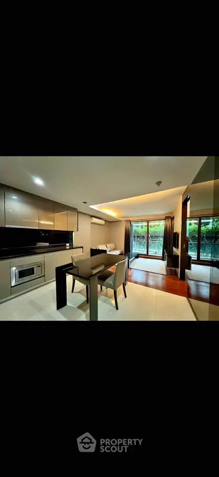 Modern open-layout kitchen and living room with sleek design and large windows.