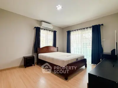 Spacious bedroom with natural light and modern furnishings in a stylish home.