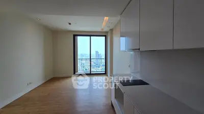 Modern apartment with open kitchen and stunning city view from balcony.