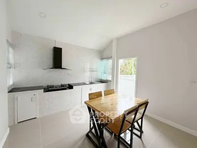 Modern kitchen with sleek design, featuring gas stove and dining area, perfect for culinary enthusiasts.