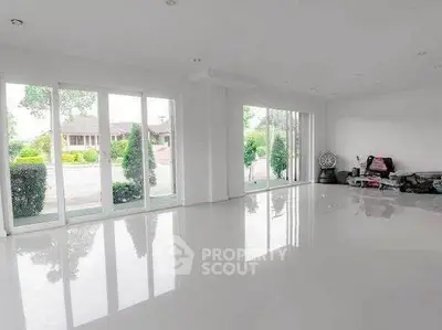 Spacious empty living room with large windows and garden view
