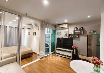 Modern living room with open layout, featuring a cozy bedroom and sleek kitchen area.