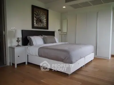 Modern bedroom with elegant decor and wooden flooring in a stylish apartment.
