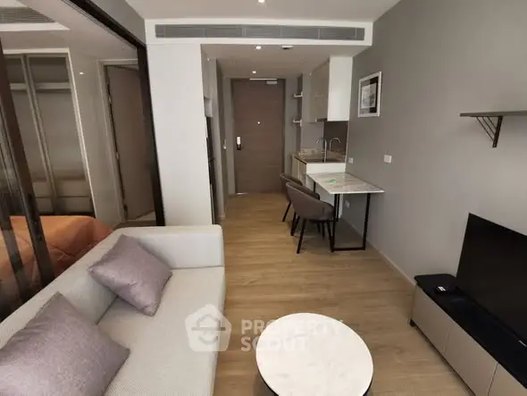Modern studio apartment with sleek design, featuring a cozy living area and compact kitchen.