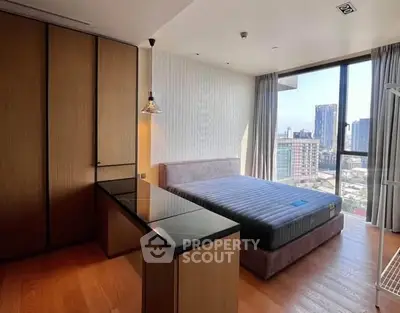 Modern bedroom with city view, featuring sleek furniture and large windows for natural light.