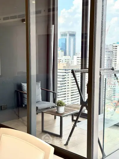 Stylish balcony with city view, modern furniture, and glass doors in urban apartment.
