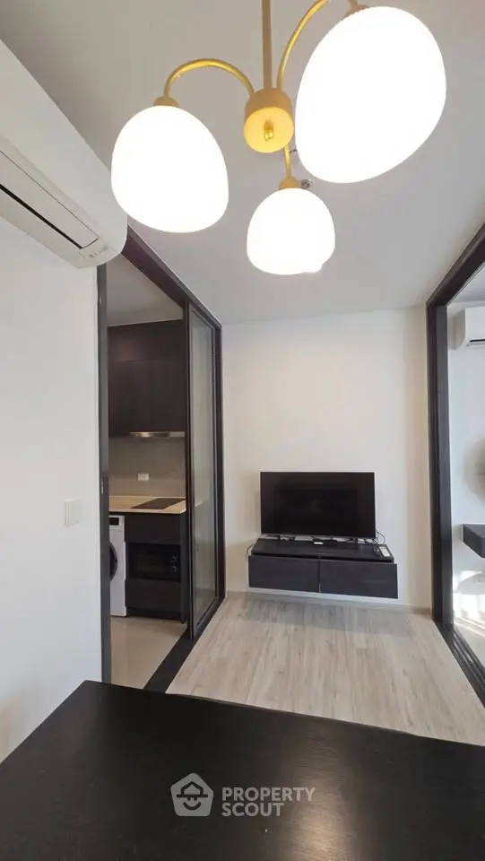 Modern apartment interior with open layout, featuring a cozy living area and sleek kitchen appliances.