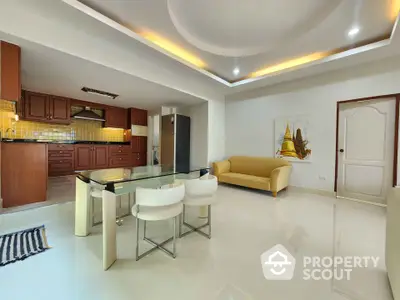 Spacious open-plan living room with modern kitchen and elegant ceiling design.