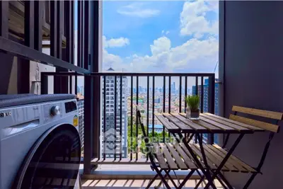 Chic urban balcony with washer, table, and stunning city view