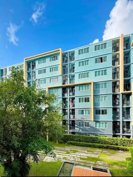 Modern apartment building with lush greenery and clear blue sky