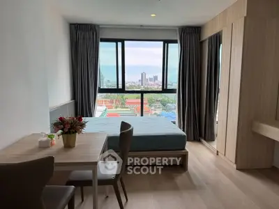 Modern bedroom with city view, featuring stylish furniture and large windows for natural light.