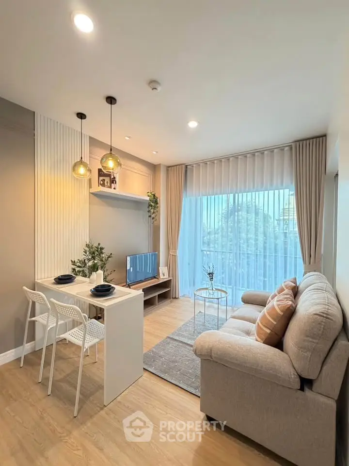 Modern living room with cozy sofa, stylish lighting, and large window offering natural light.