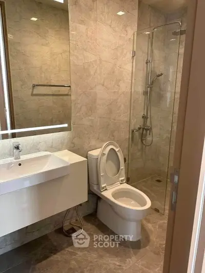 Modern bathroom with glass shower and sleek fixtures in a contemporary apartment.