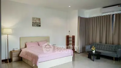 Spacious bedroom with modern decor, featuring a cozy bed, elegant sofa, and stylish lighting.